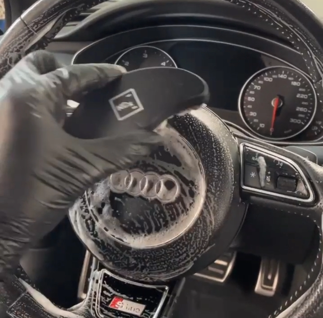 Audi Lenkrad Tiefenreinigung - Professionelle Innenraumreinigung eines Audi Lenkrads mit speziellen Reinigungsmitteln für hochwertige Lederpflege.